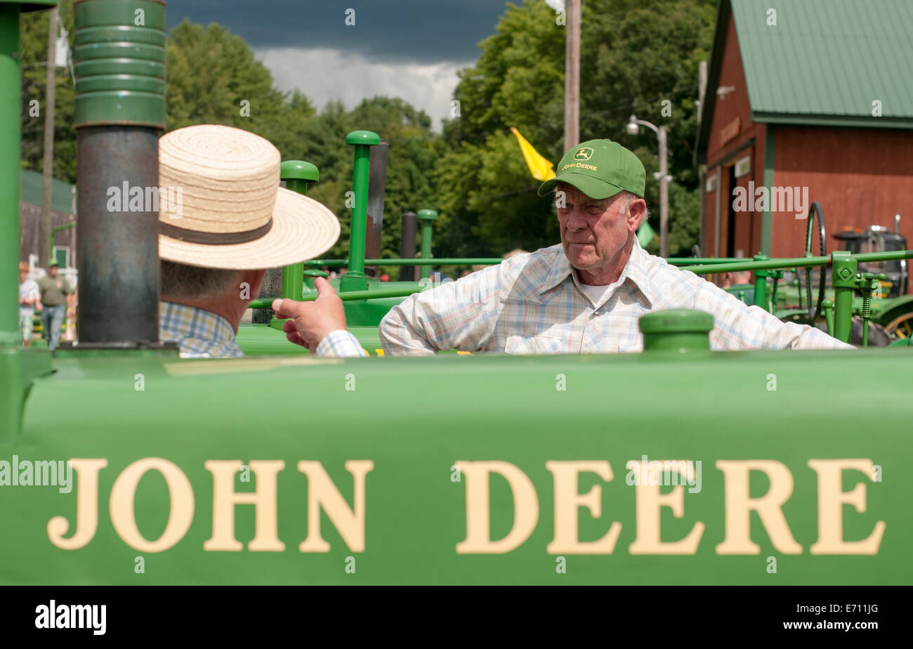 Dos hombres con sombreros discutir tractores un tractor John Deere expo en New Hampshire Fotografía de stock -