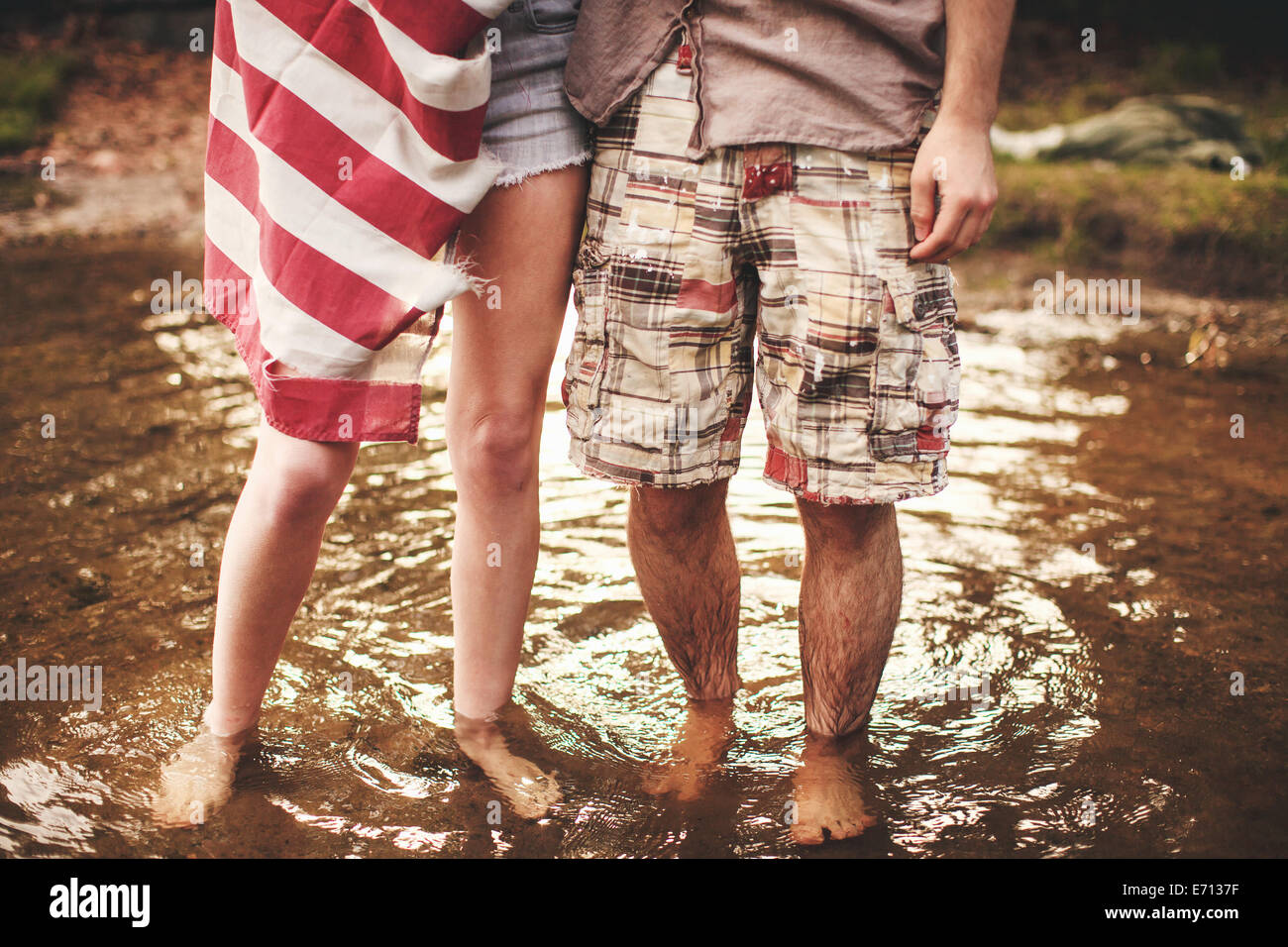 Pareja joven de pie en aguas poco profundas Foto de stock
