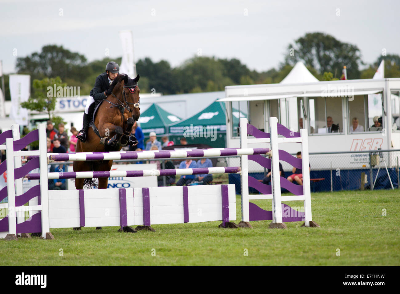 Un jinete y su caballo saltar una valla en el concurso hípico en Edenbridge y Oxted Show agrícola en Surrey Foto de stock