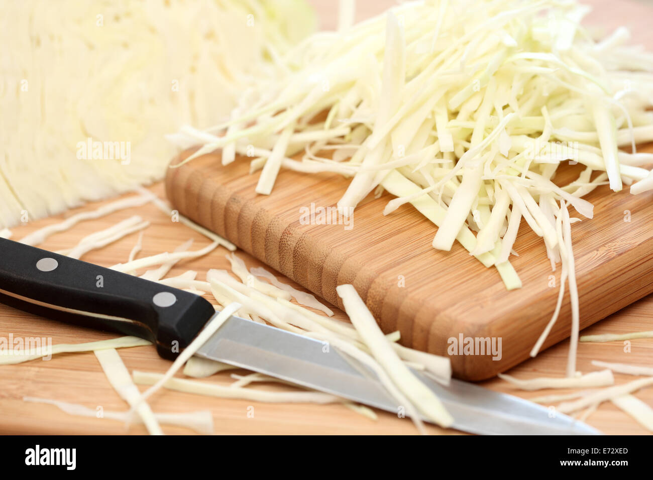 https://c8.alamy.com/compes/e72xed/repollo-desmenuzado-sobre-la-tabla-de-cortar-y-el-cuchillo-sdof-closeup-e72xed.jpg