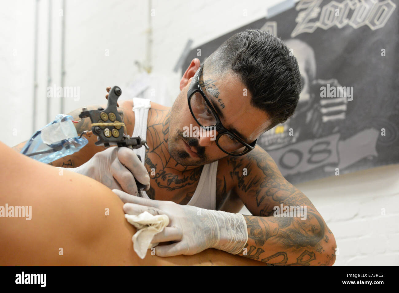 Londres, Reino Unido. El 5 de septiembre de 2014. Un artista "tatuaje" Zordo tatuaje es un cliente con ocasión de la 2ª Convención Internacional de tatuaje de sordos en St. John's Comunidad Sorda Centre en Londres. Crédito: Ver Li/Alamy Live News Foto de stock