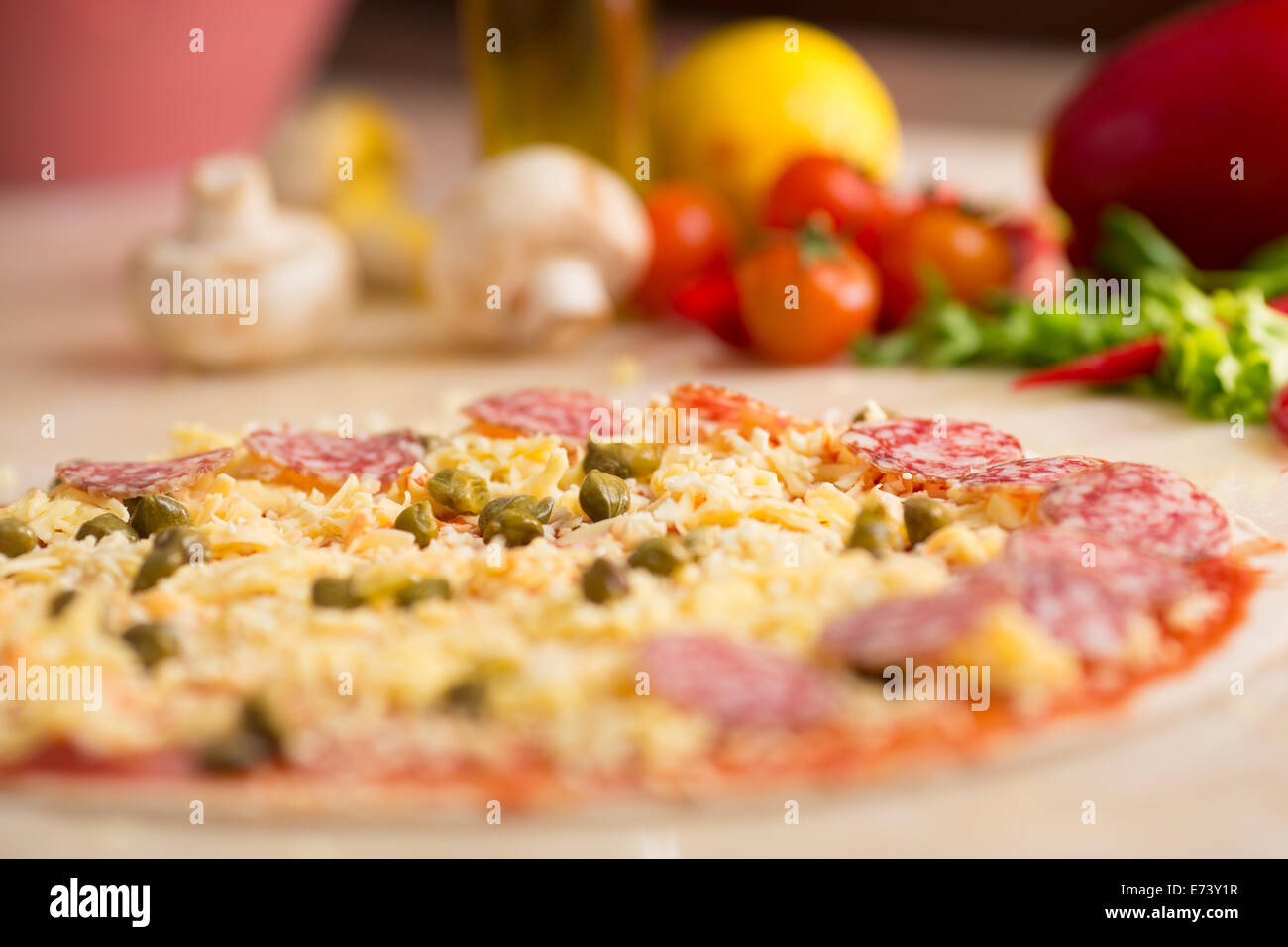 Materias salami pizza en la mesa con los ingredientes Foto de stock