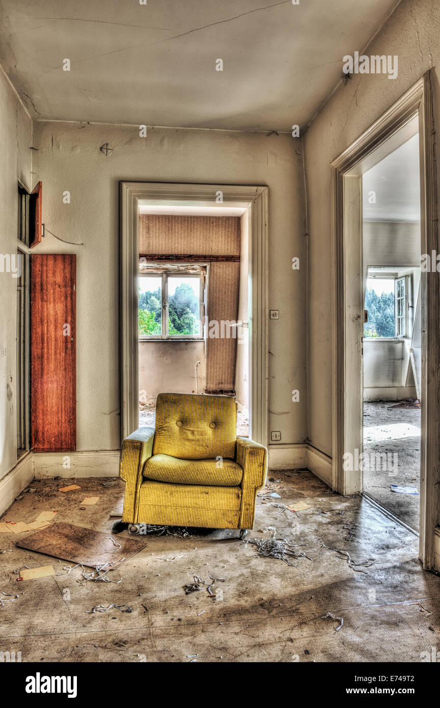 Sillón amarillo en una casa abandonada Foto de stock
