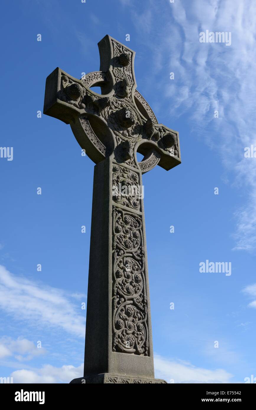 Cruz celta monumento de piedra en la necrópolis de Glasgow contra un cielo azul profundo Foto de stock
