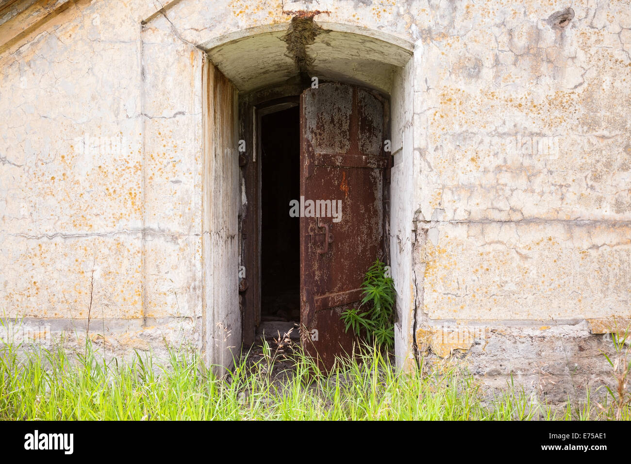 Abrir puerta oxidado en el viejo muro de fortificación, textura de fondo Foto de stock