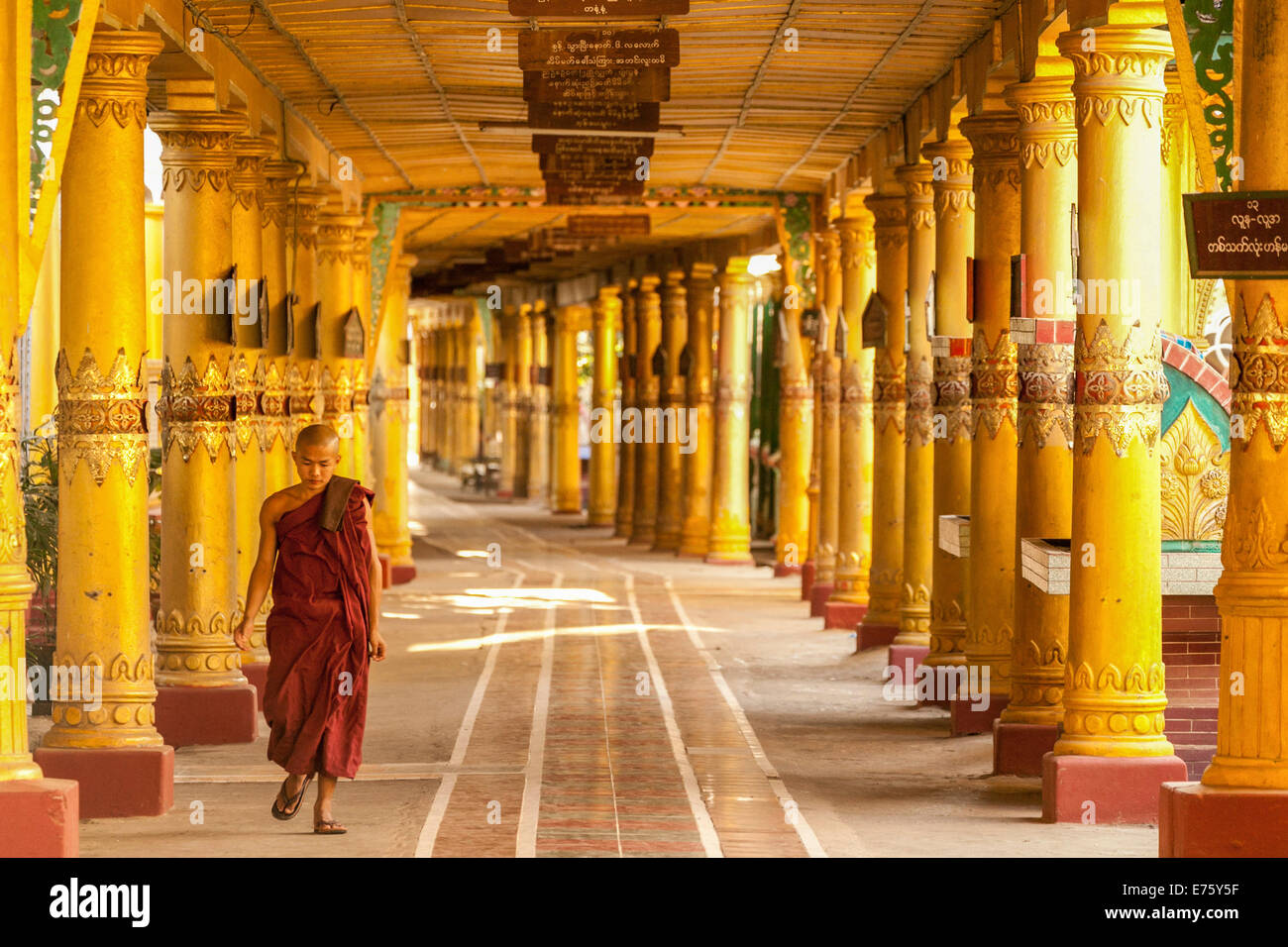 Estudiante monje budista caminando a través de pórtico, Bago, Myanmar Foto de stock