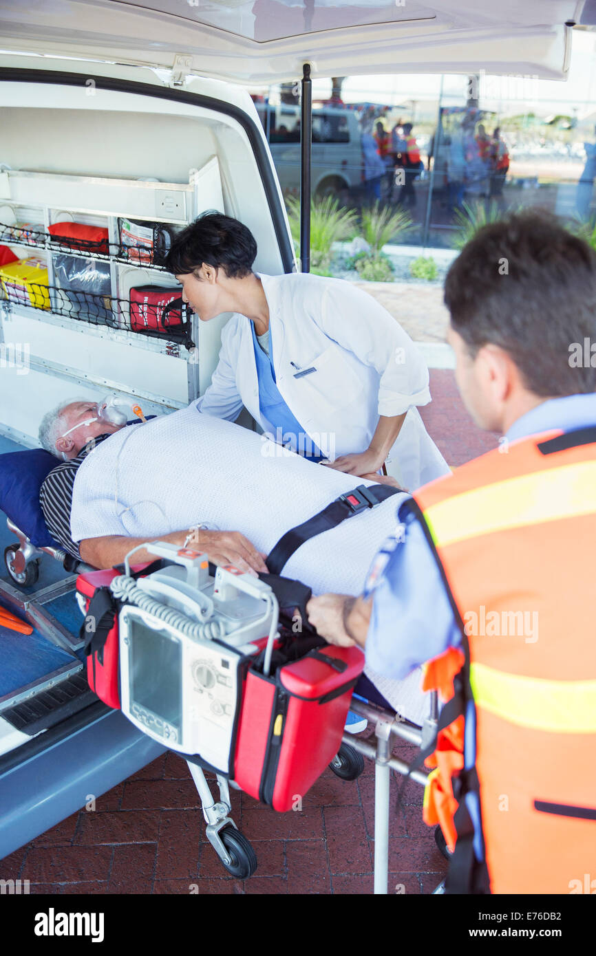 Médico examina al paciente en ambulancia camilla Foto de stock