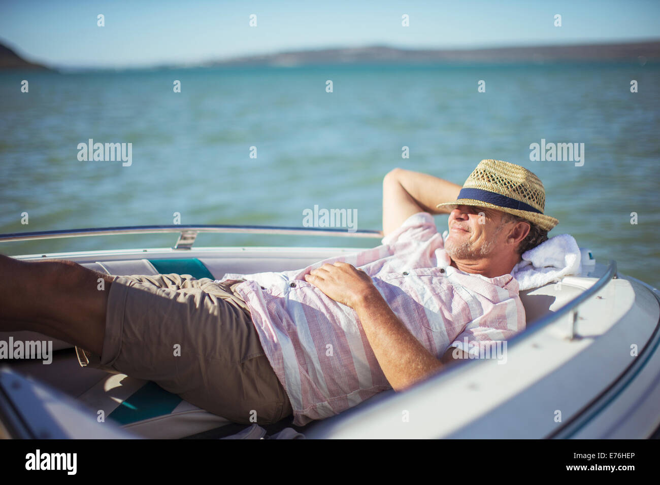 Anciano relajante en bote sobre el agua Foto de stock