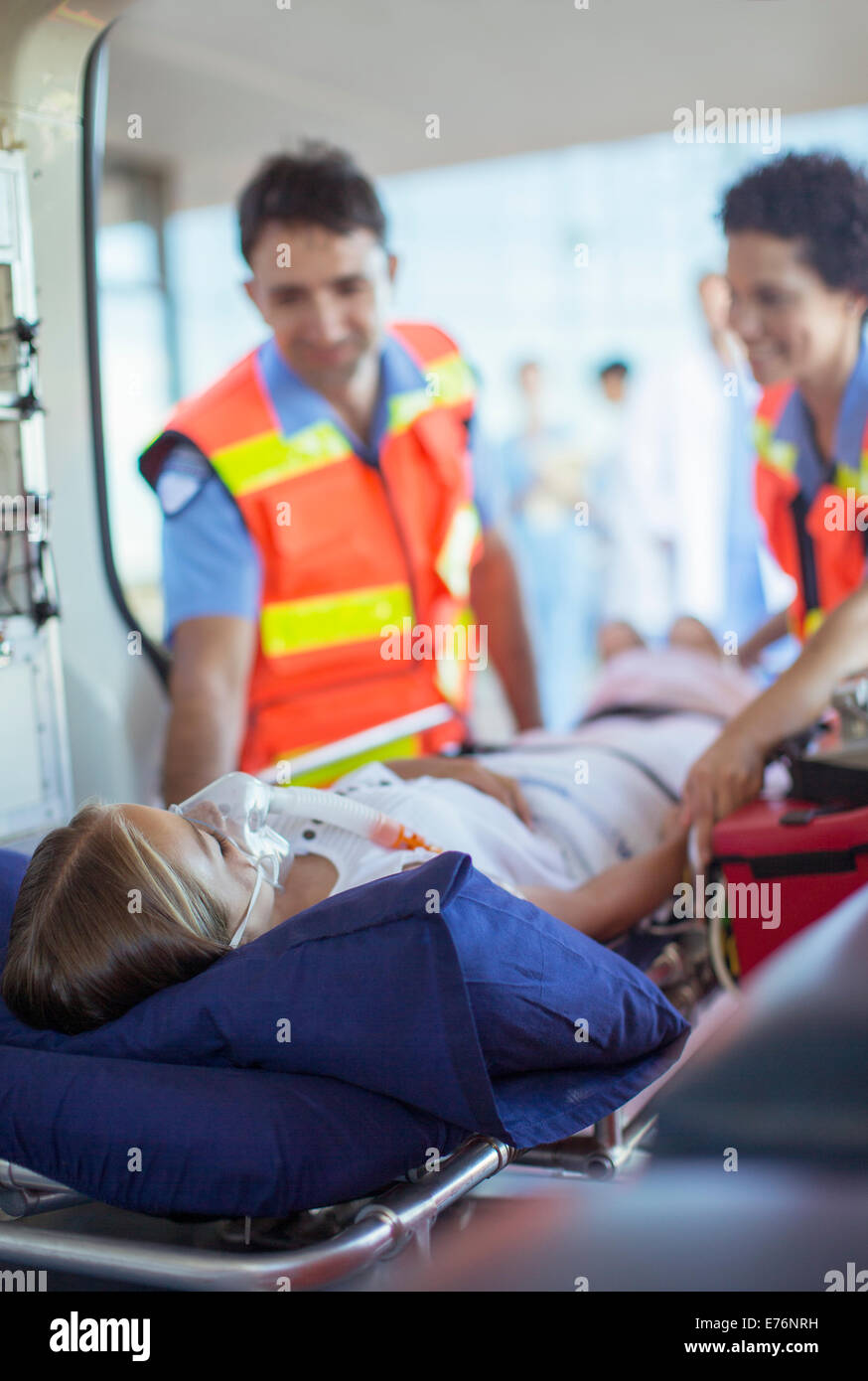 Paramédicos examinar al paciente en ambulancia camilla Foto de stock