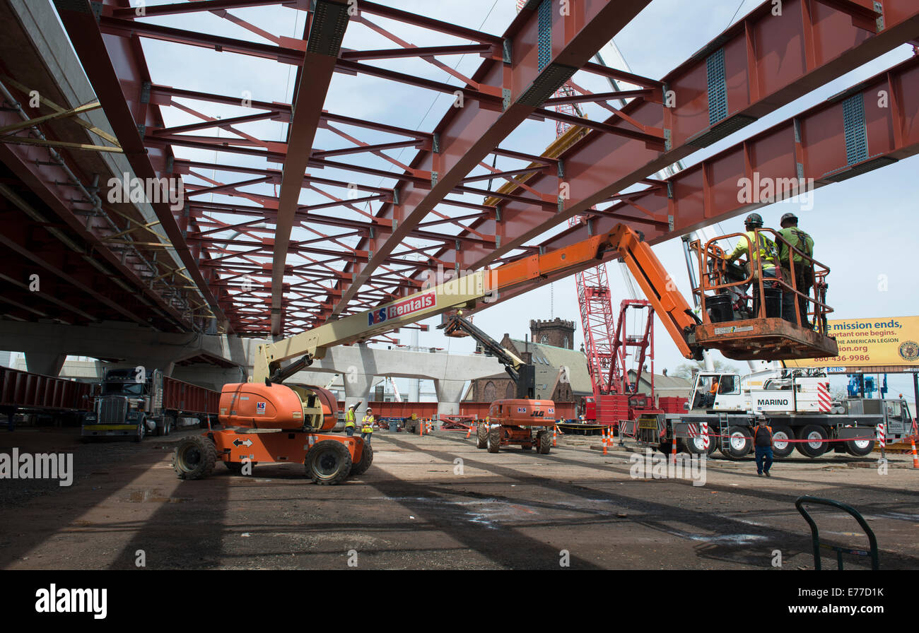 Los trabajadores de hierro sobre una plataforma de elevación prepárese para fijar nuevas vigas de acero para el nuevo puente en New Haven Harbour Crossing Project. Foto de stock