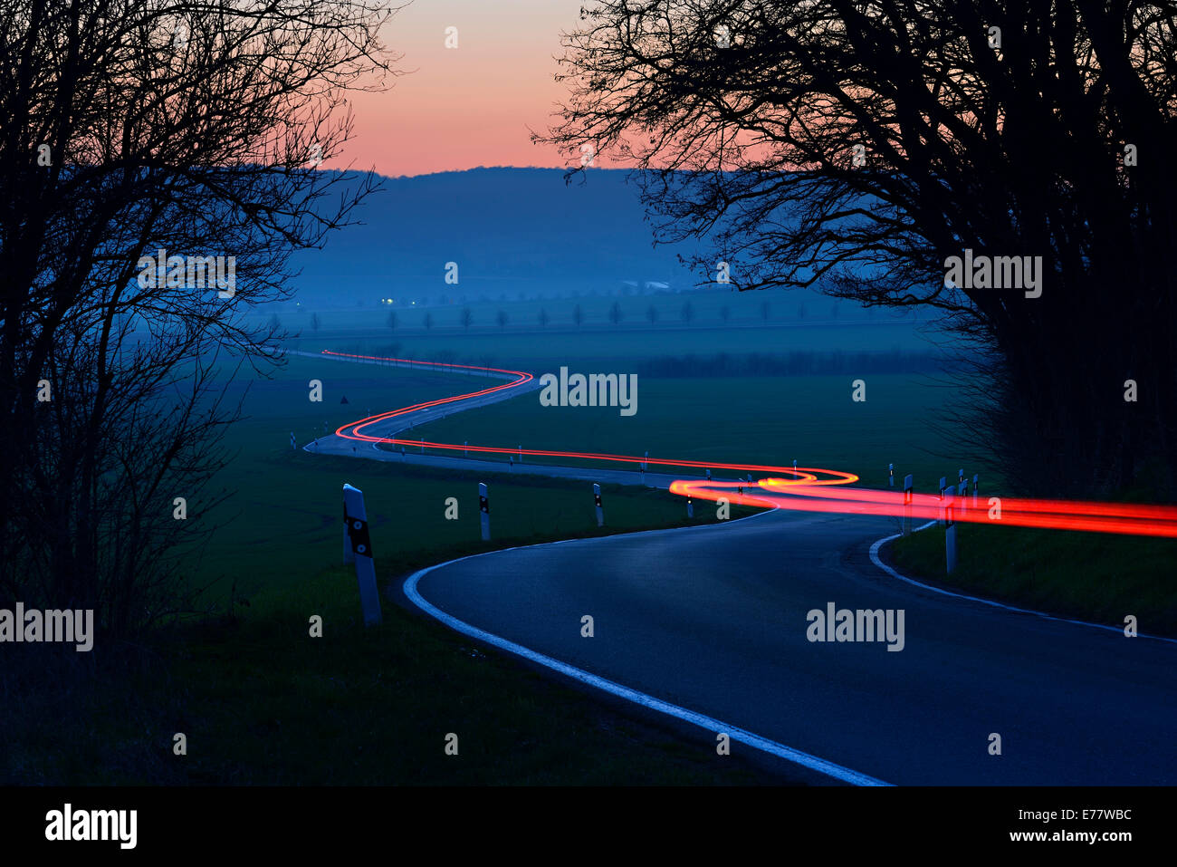 Estelas de luz sobre un sinuoso camino campestre, Night Shot, una exposición larga, Sajonia-Anhalt, Alemania Foto de stock