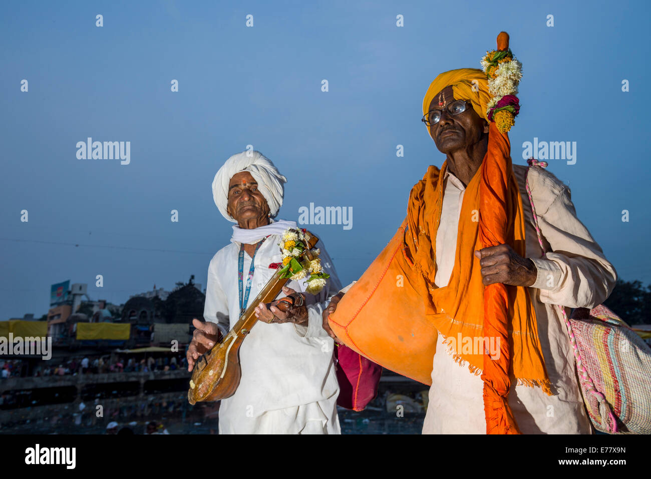 Dos devotos con sus instrumentos de música en los bancos del río Santo Godwari, Nasik, Maharashtra, India Foto de stock