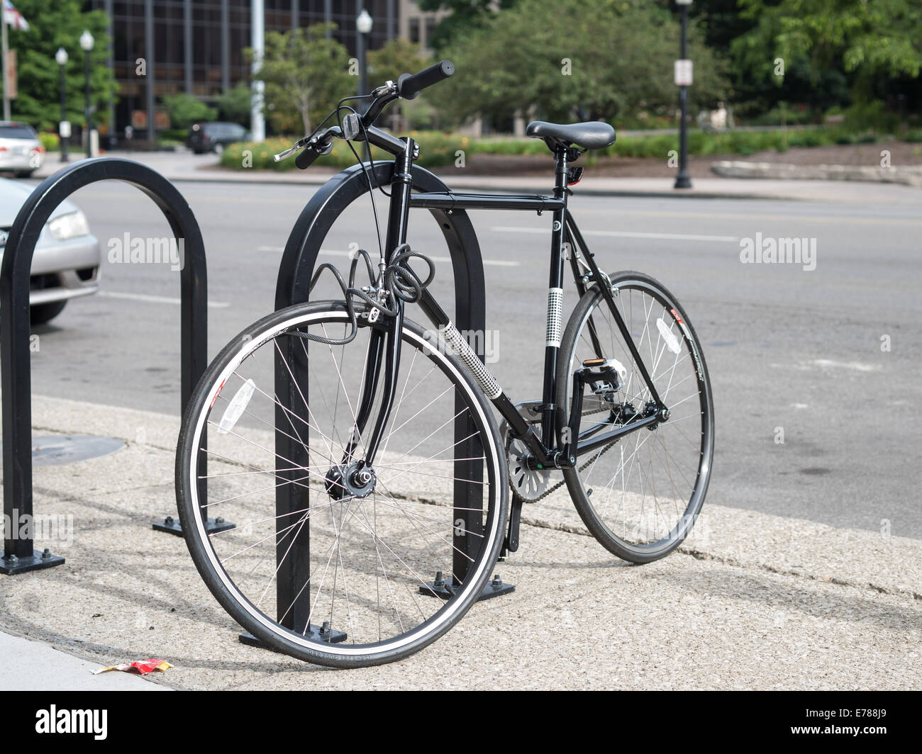 Una bicicleta estacionada en un portabicicletas junto a la calle en Columbus (Ohio) Foto de stock