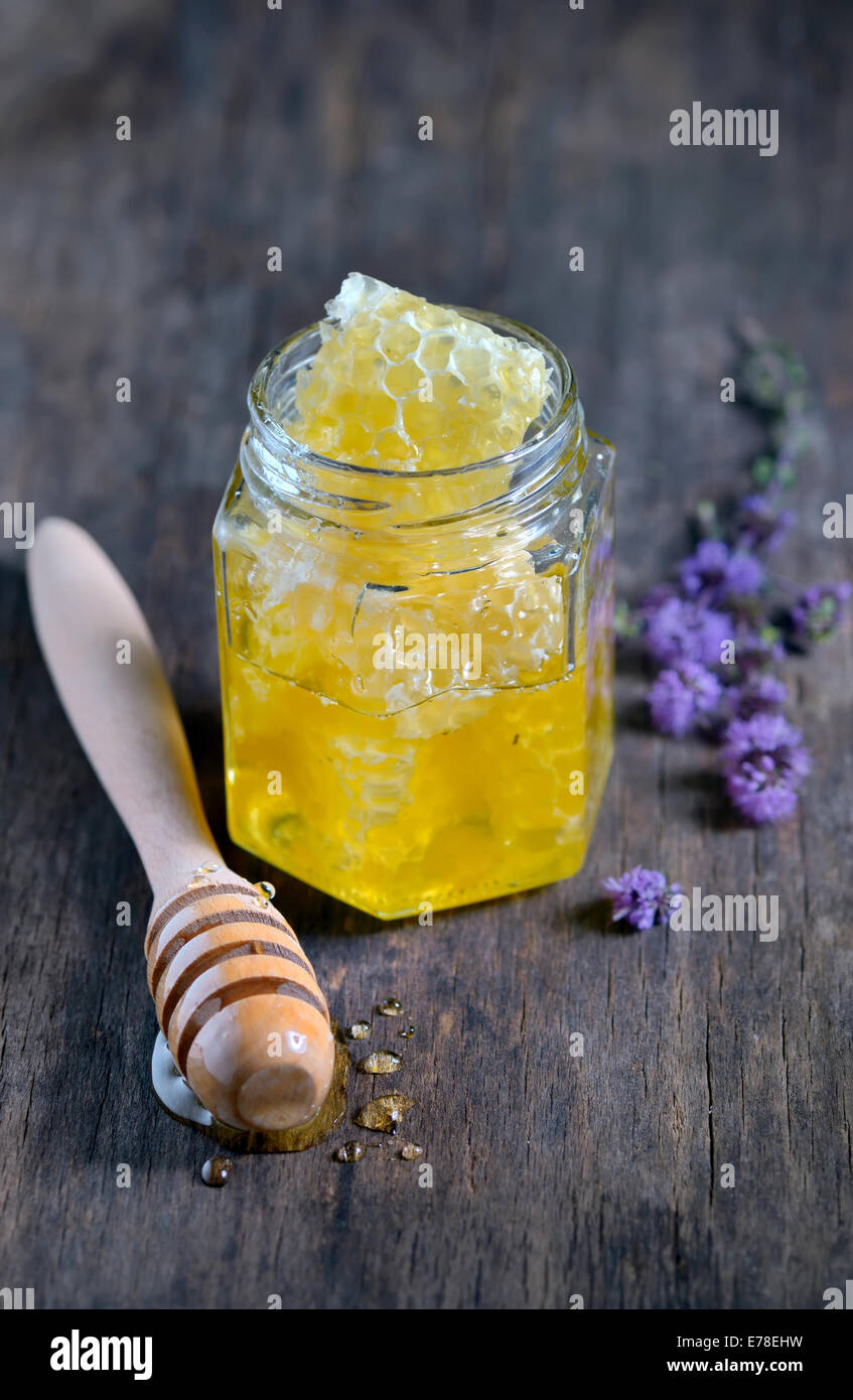 Panal con abejas y frasco de miel en mesa Fotografía de stock - Alamy