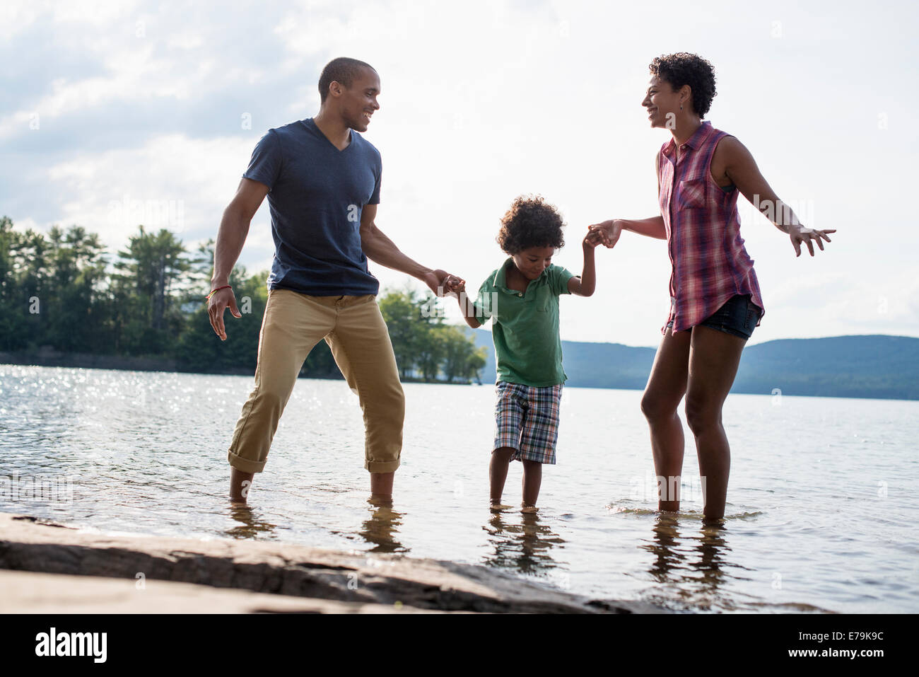 Una familia, los padres y el hijo de un lago en verano. Foto de stock