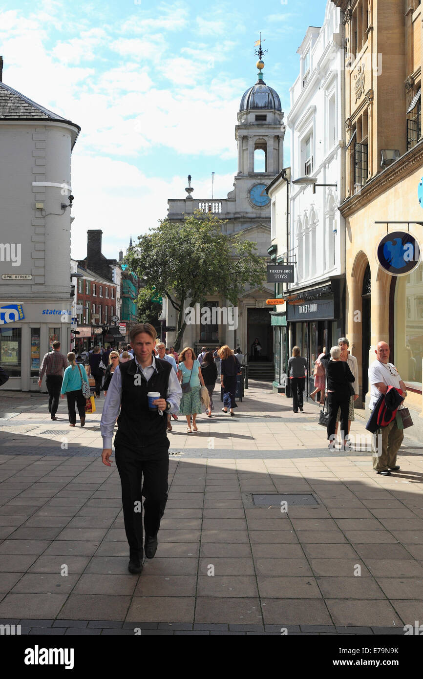 El hombre lleva un café para llevar en una calle del centro de la ciudad de Norwich a la hora del almuerzo. Foto de stock