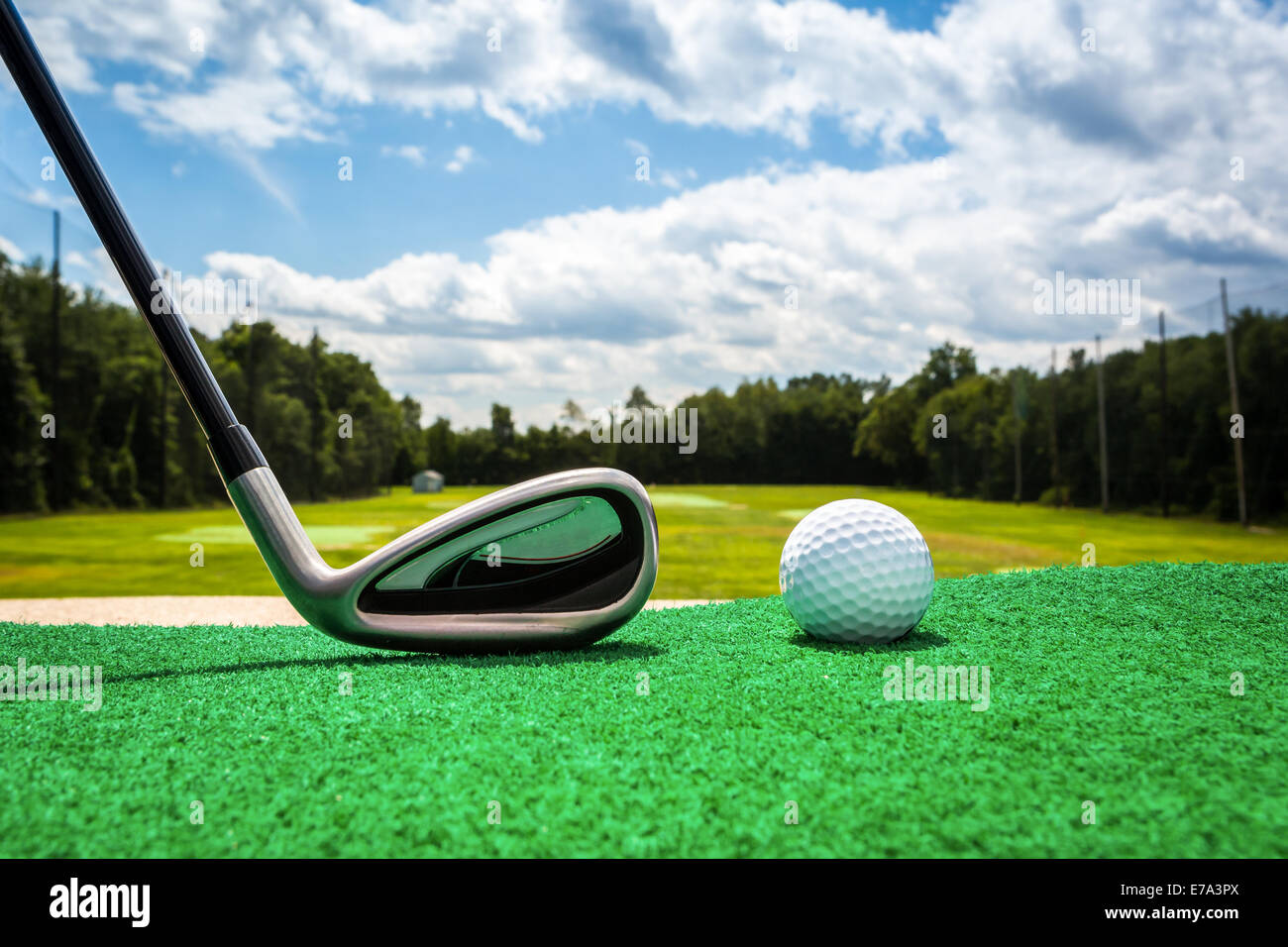 Close-up de una pelota de golf y campos de golf de hierro en un driving range Foto de stock
