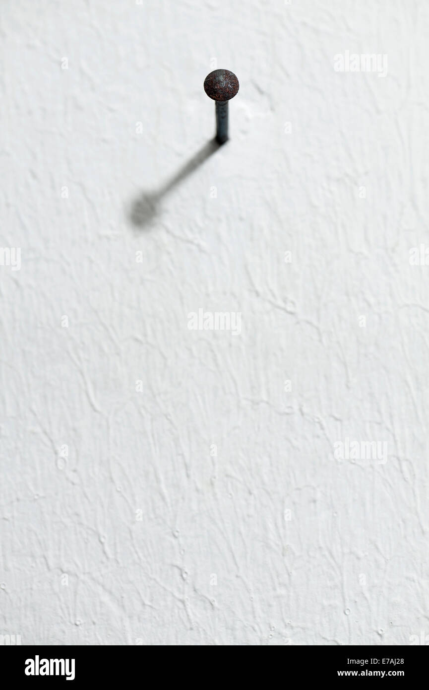 Primer plano del clavo en la pared blanca al bastidor Foto de stock