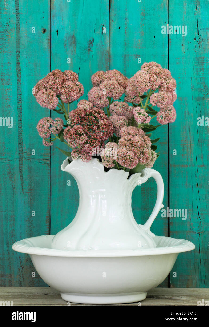 Blanco antiguo jarra de agua y una palangana con flores de madera  desgastada por fondo verde Fotografía de stock - Alamy