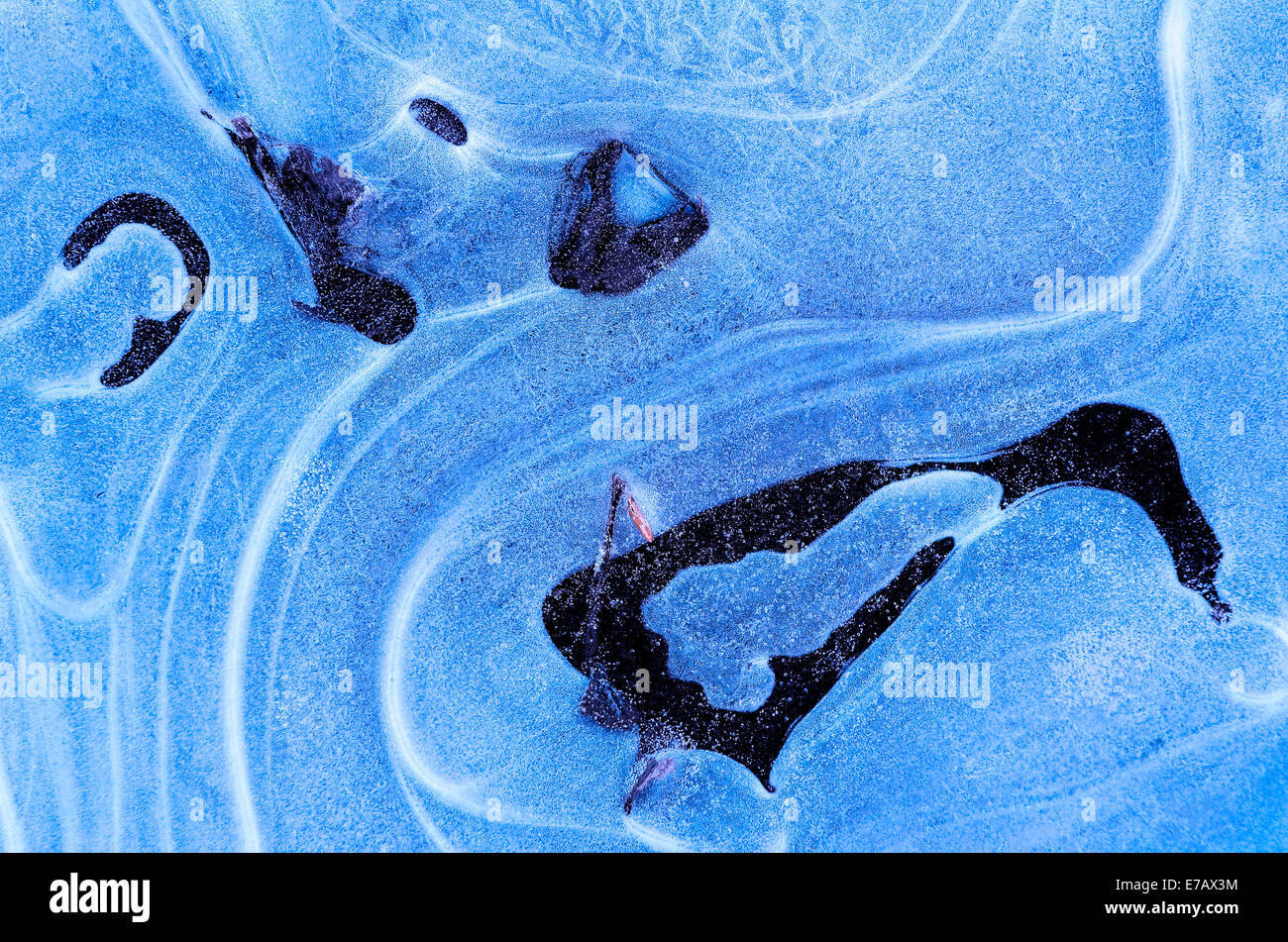Arroyo congelado resultando en patrones de cristal de hielo azul translúcido Foto de stock