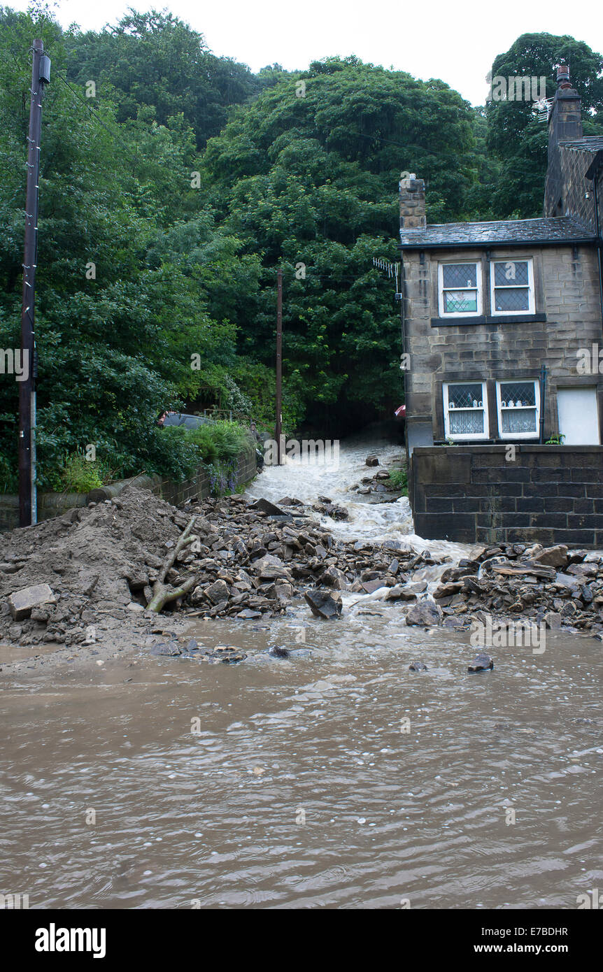 Las aguas de la inundación de un torrente desbordado" el lavado de escombros en una carretera en Hebden Bridge, West Yorkshire, Reino Unido Foto de stock