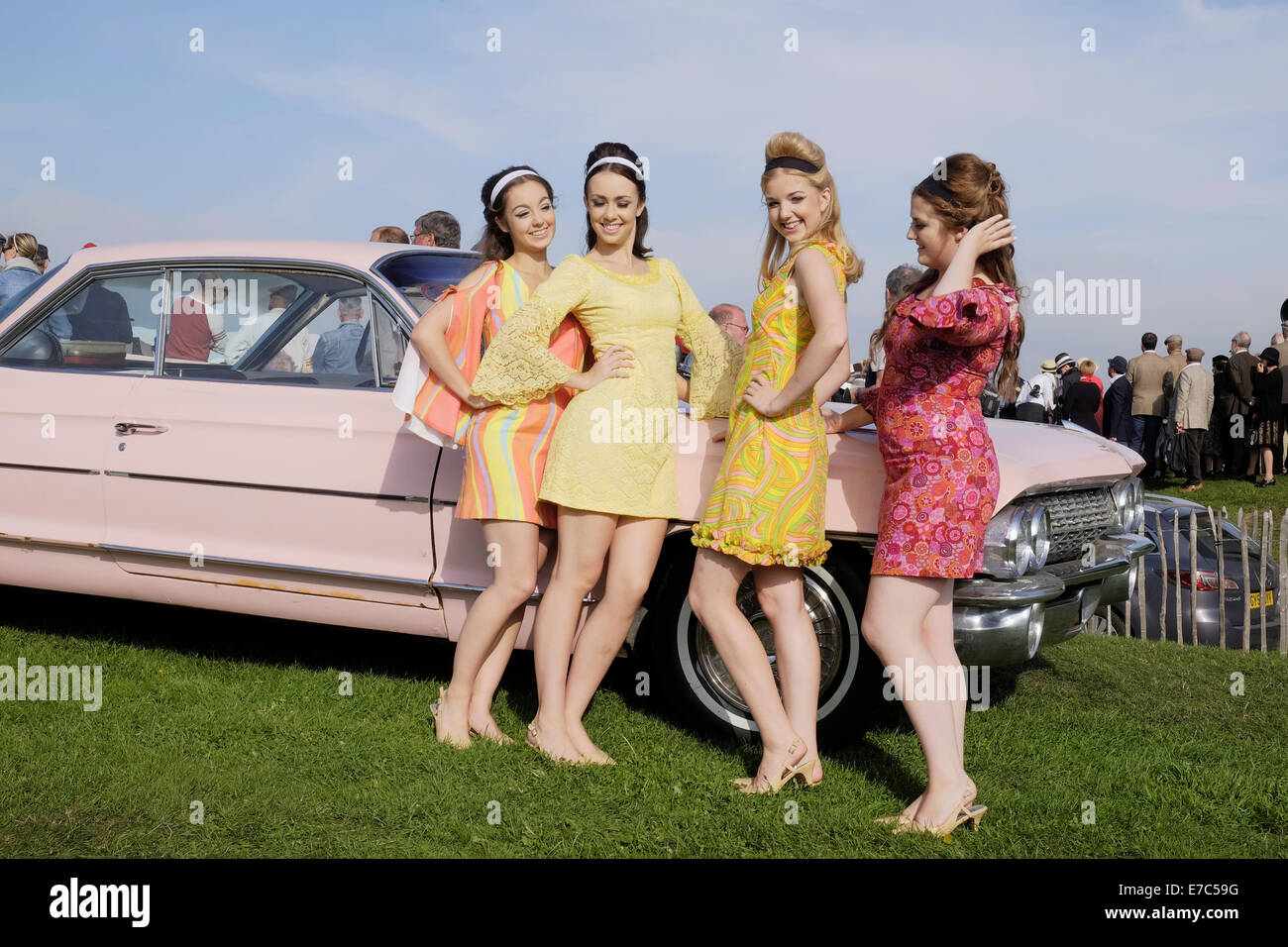 Cuatro muchachas jóvenes en la adolecencia tardia veinte vestida de vintage 60s  ropa de moda con vestidos de colores brillantes, el cuarteto de niñas  estaban poniendo en un acto donde se llevó