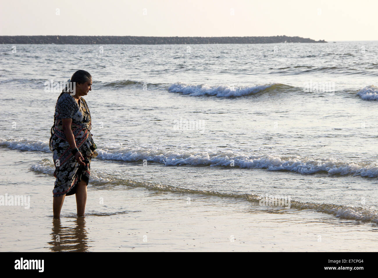 Mujer curiosamente observando las olas del mar en Mangalore, Karnataka, India, Asia Foto de stock