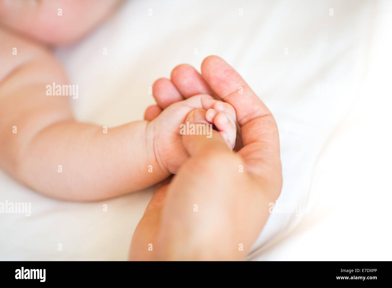 Padre sosteniendo la mano de su hijo recién nacido, someras DOF Foto de stock