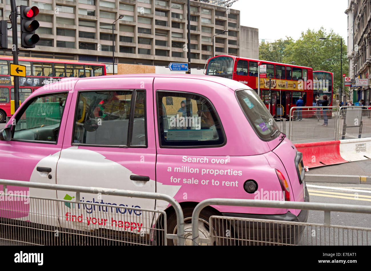 Pink Taxi londinense con mendigo visto a través de la ventana red bus en el fondo Foto de stock