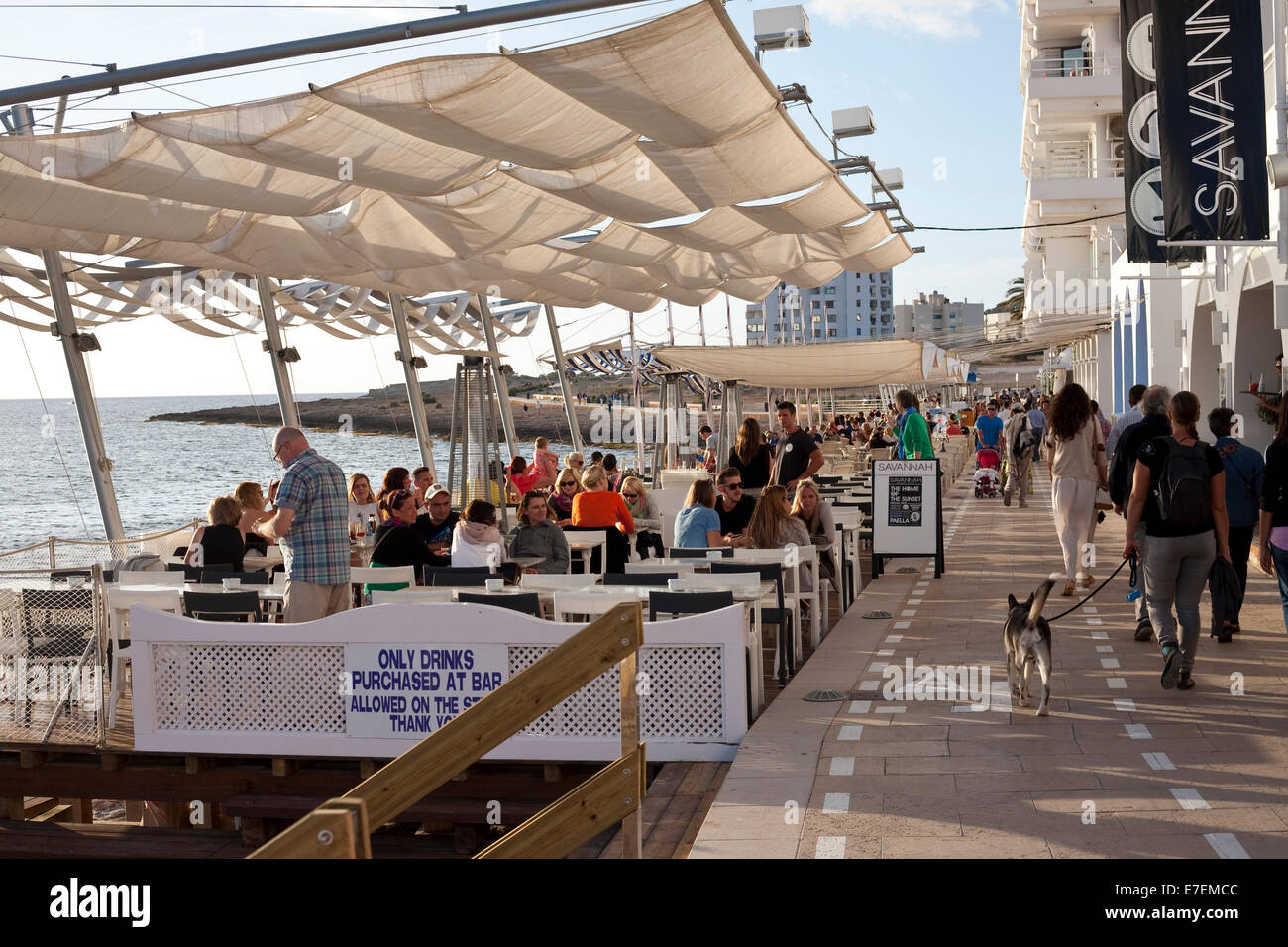 Los turistas disfrutan de un trago en un bar en una zona próxima a la costa en Ibiza Foto de stock