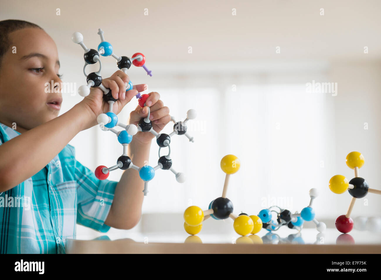 Mestizos boy jugando con modelos moleculares Foto de stock
