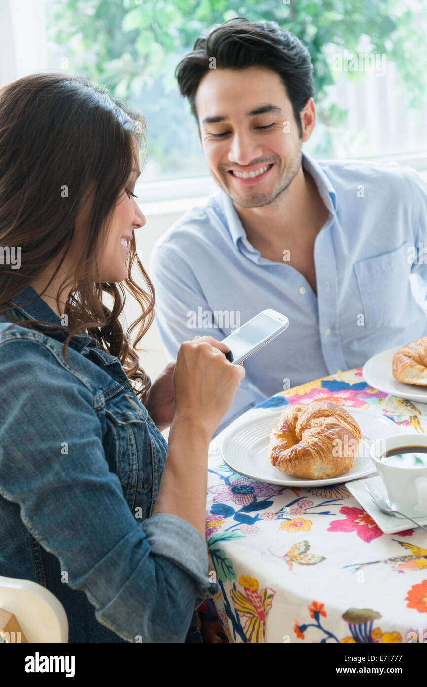 Mujer fotografiando croissant Foto de stock