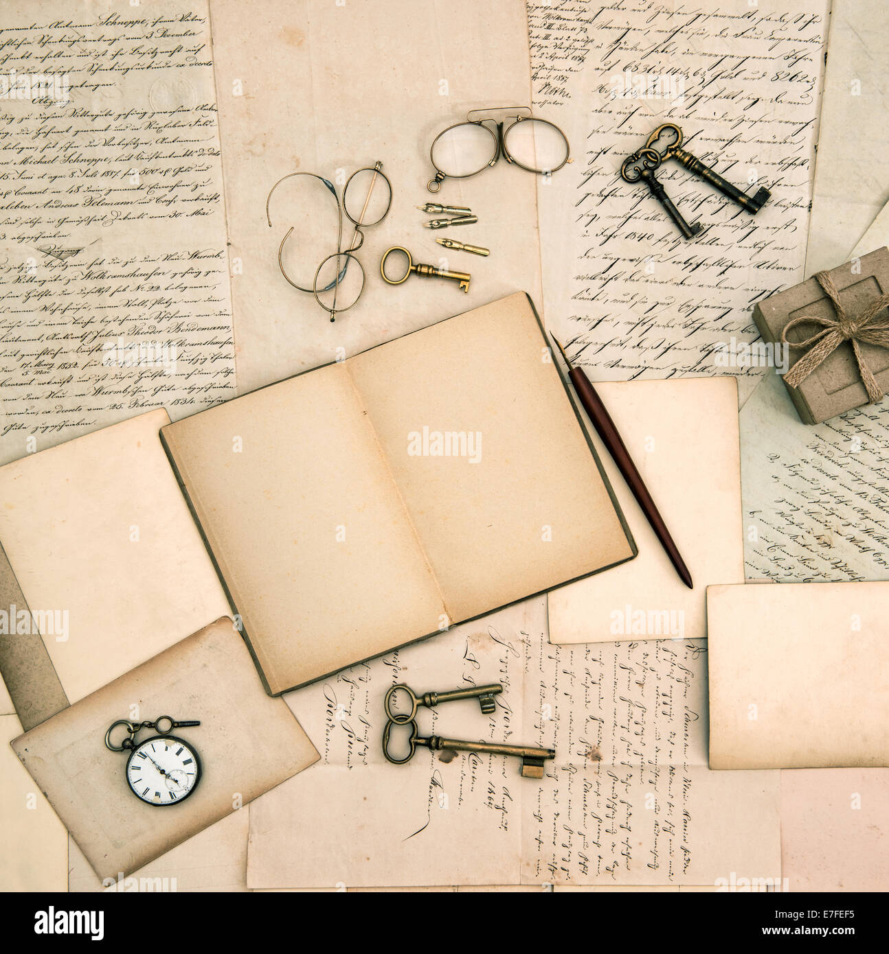Abrir libro de recuerdos, accesorios vintage, viejas cartas y documentos de antecedentes nostálgico. Foto de stock