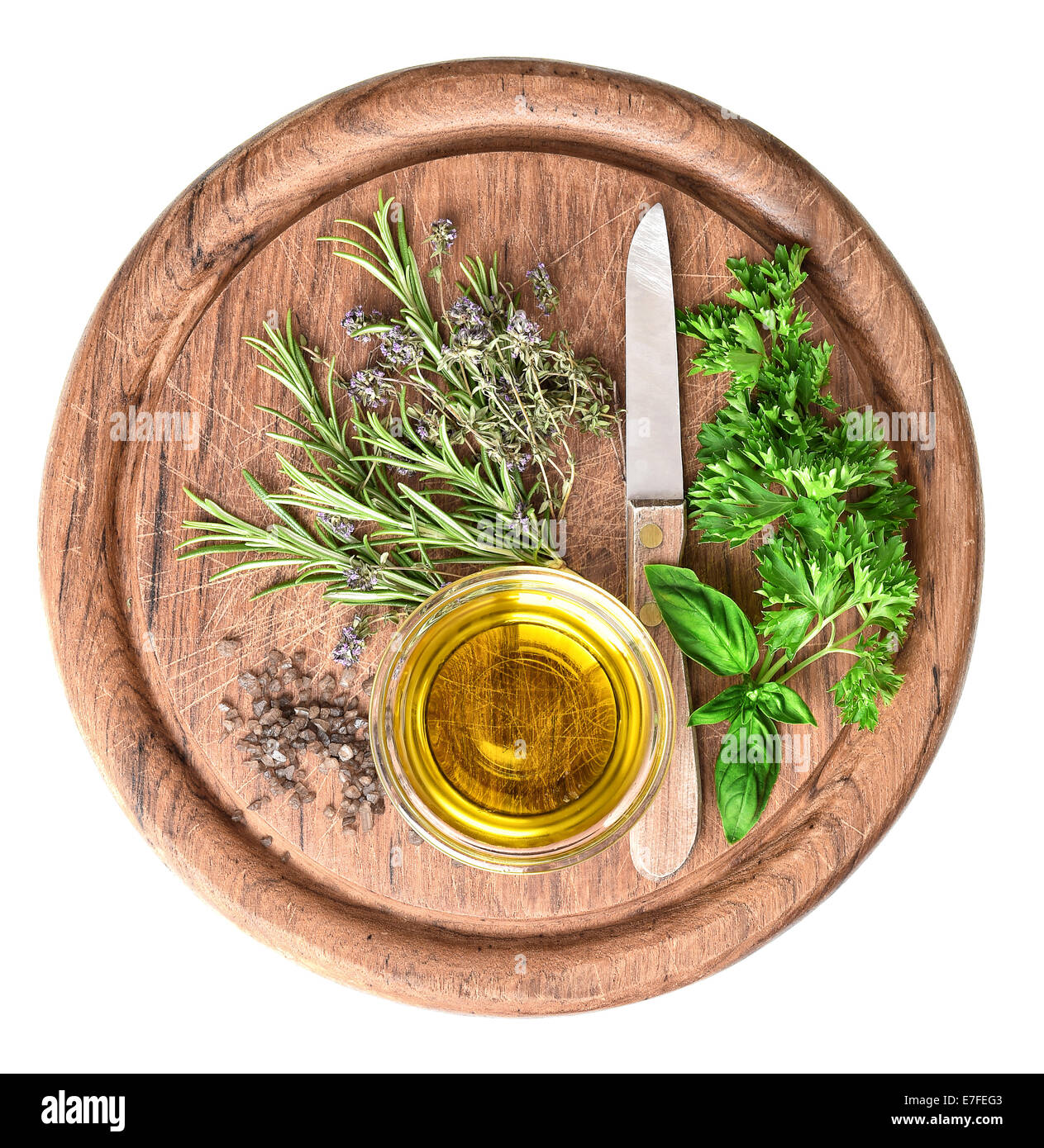 El aceite de oliva con hierbas frescas, tomillo, albahaca y romero sobre placa de cocina de madera Foto de stock