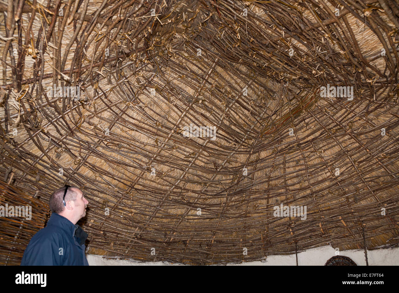 Los turistas de techo con techo de paja en la edad de piedra neolítica recreado cabaña / stoneage chozas. Exposición; el centro de visitantes de Stonehenge / Stone Henge UK Foto de stock