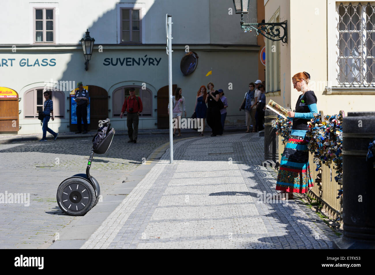 Un agente del Segway principales contra la barandilla de un puente cubierto con una serie de candados cerrados, Praga, República Checa. Foto de stock