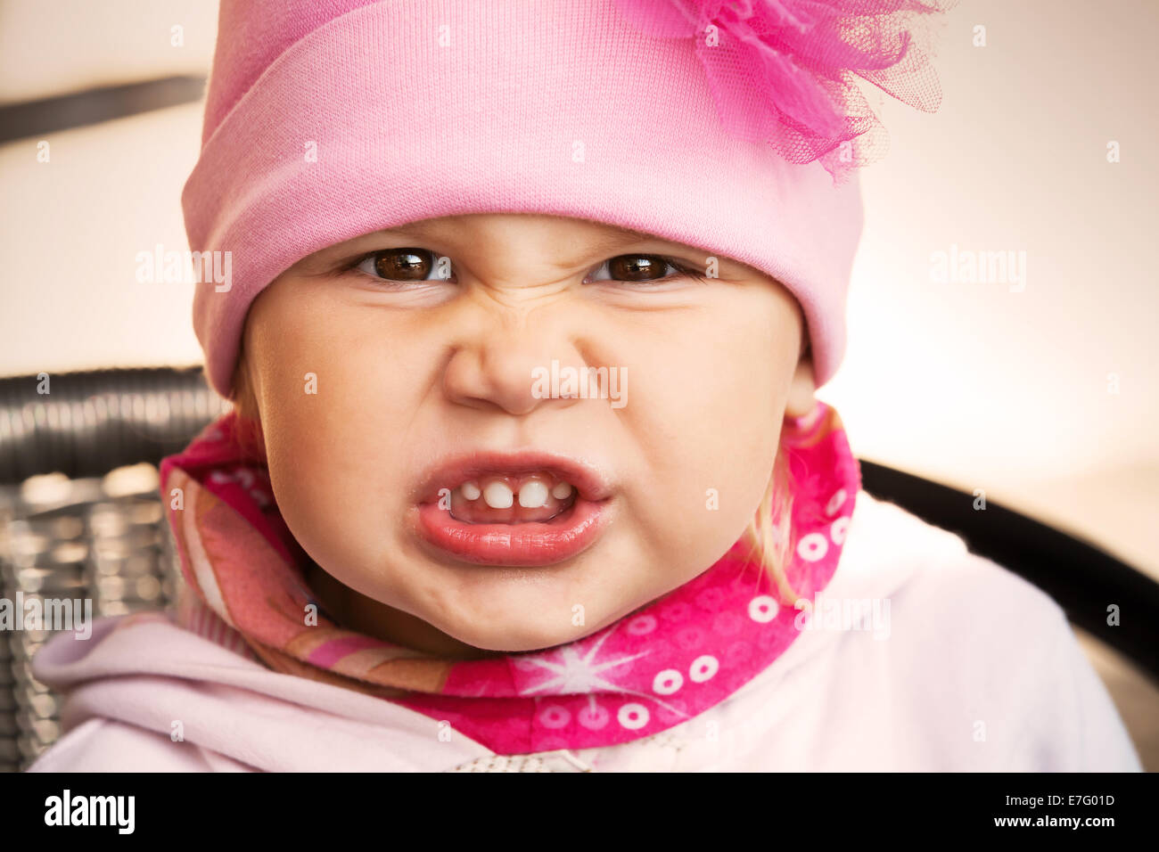 Closeup retrato de funny enojado niña rosa Foto de stock