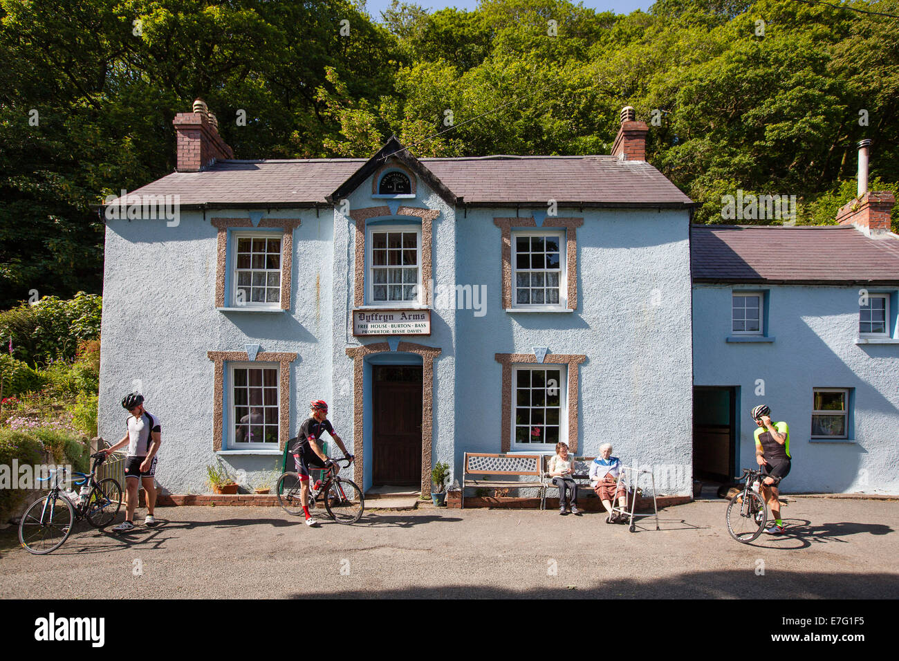 Tres ciclistas se preparan para abandonar un pub village en Pembrokeshire (Gales) Foto de stock