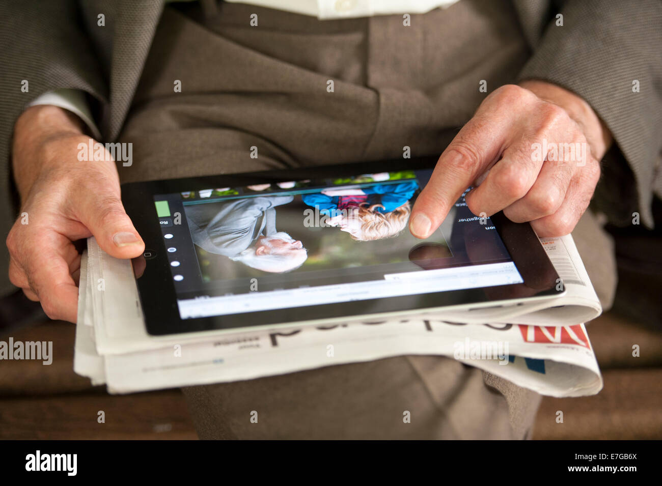 Altos hombre mirando una fotografía de un abuelo y nieto en una tableta electrónica Foto de stock