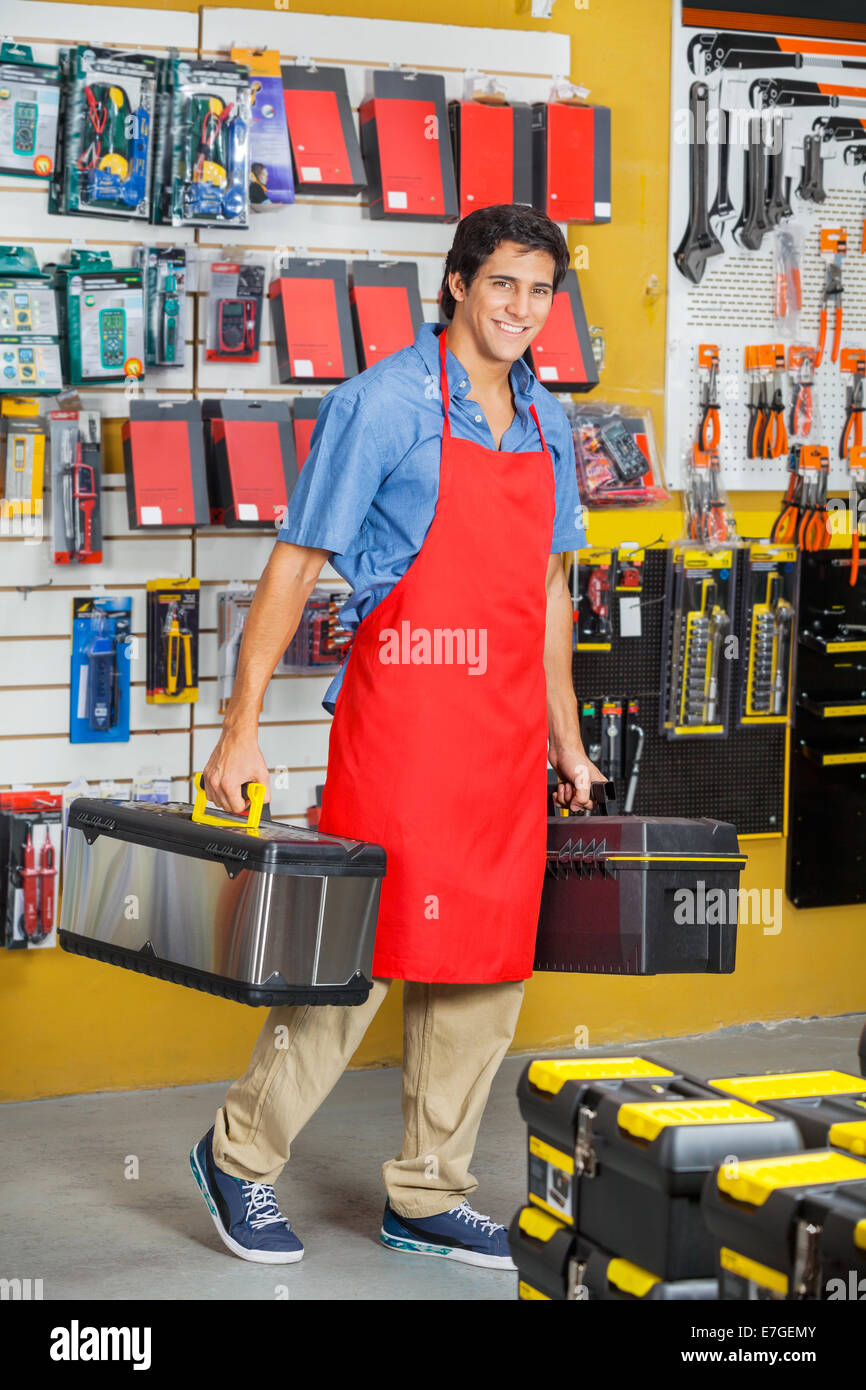Vendedor llevar cajas de herramientas mientras caminaba en la tienda Foto de stock