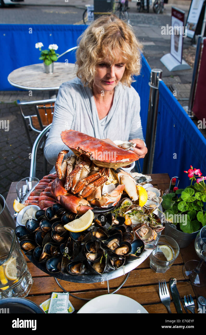 Mujer comiendo un plateau de fruits de mer con cangrejo fresco o un plato de mariscos frescos en el restaurante Brighton Reino Unido Fishy Fishy Foto de stock