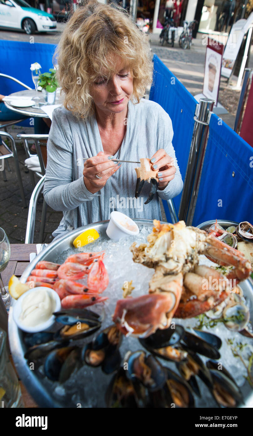 Mujer comiendo un plateau de fruits de mer con cangrejo fresco o un plato de mariscos frescos en el restaurante Brighton Reino Unido Fishy Fishy Foto de stock