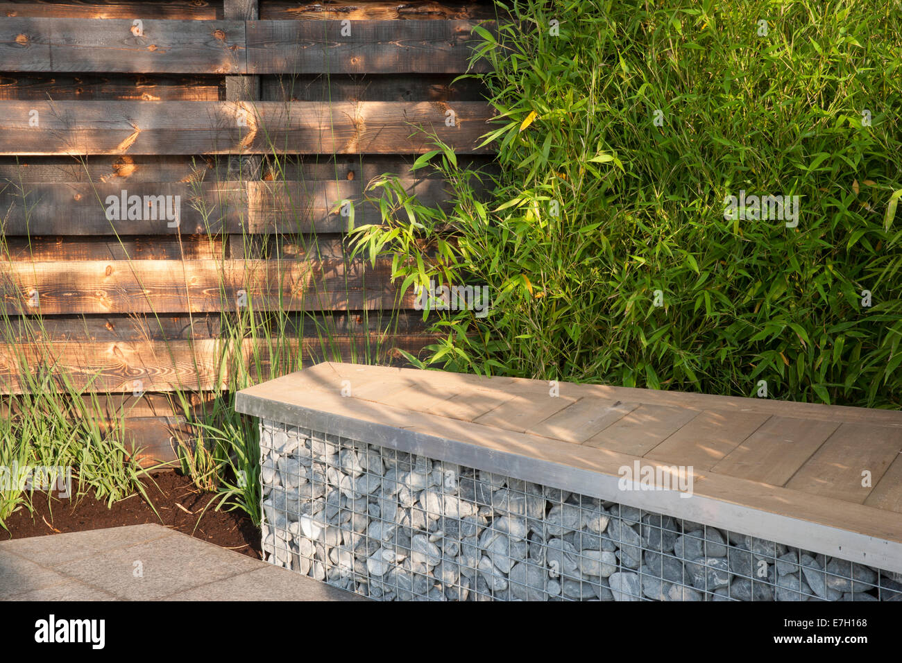 - Jardín - Elemental de BASALTO basalto y patio con adoquines en la jaula con asientos de madera de secoya plantación de bamb Foto de stock