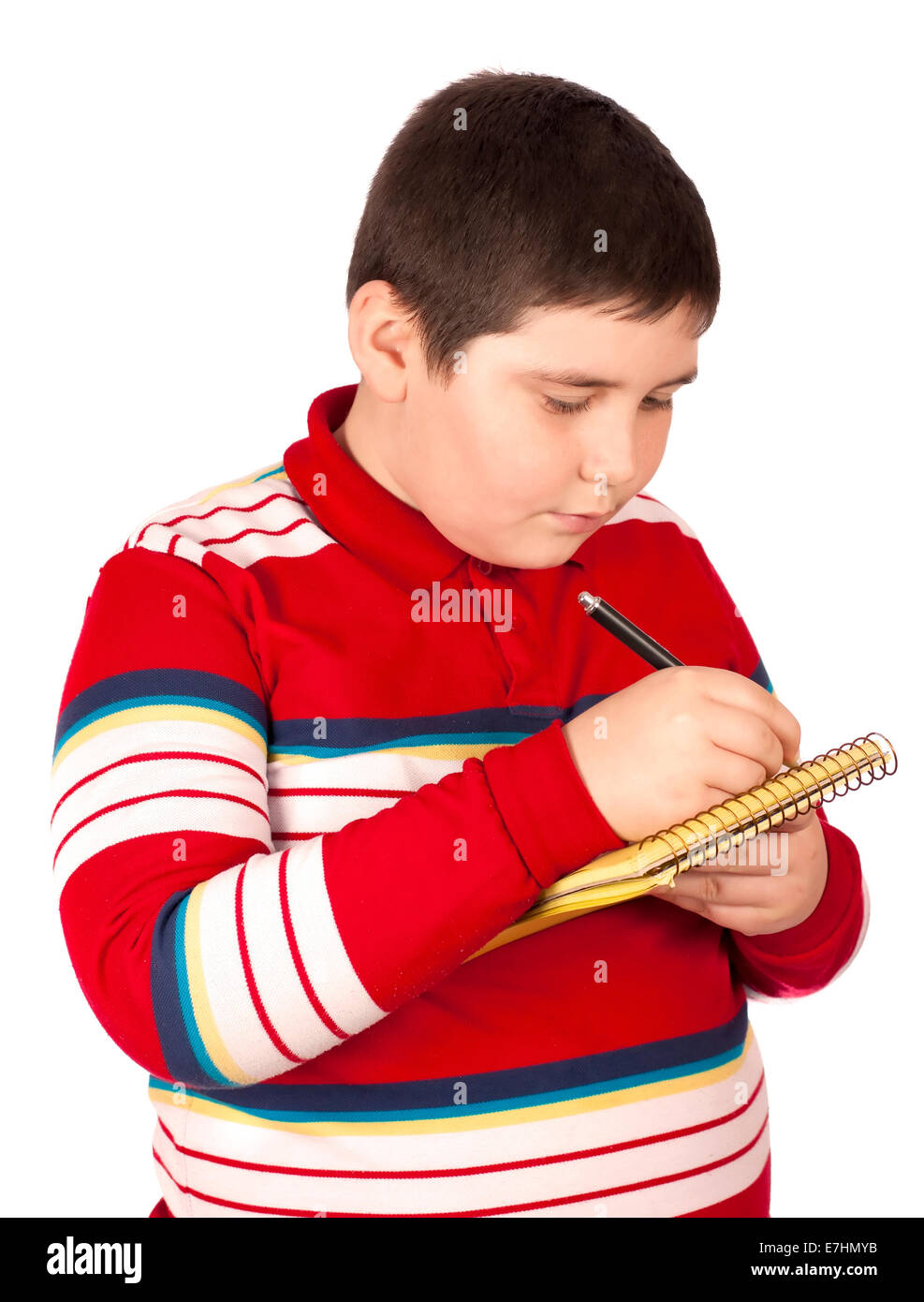 Niño que escribe en un bloc de notas aisladas sobre fondo blanco. Foto de stock