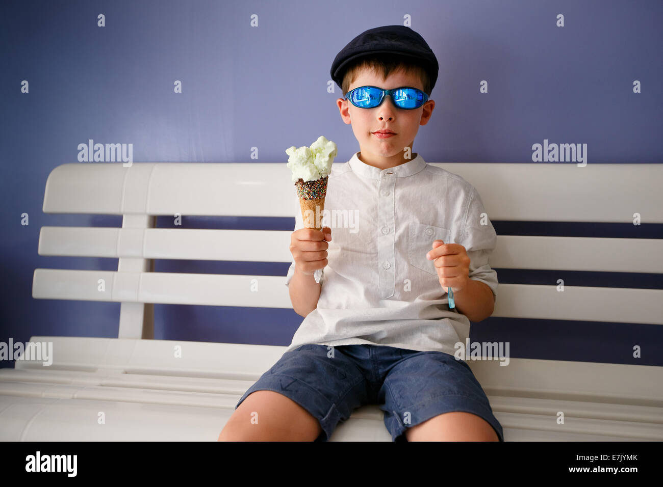 Cute little boy comer helado en la cafetería interior Foto de stock