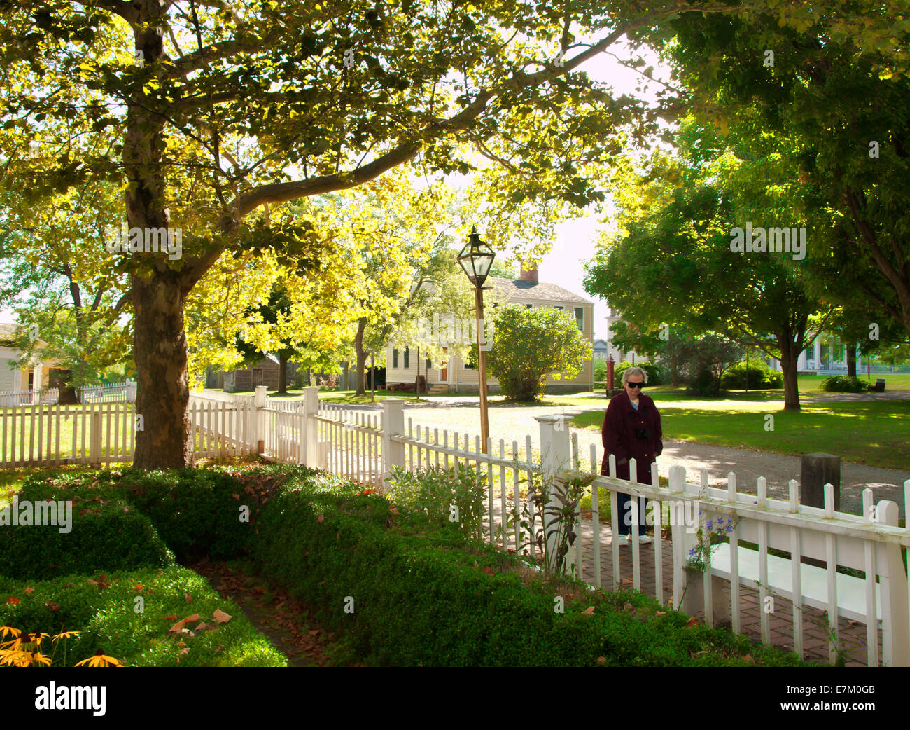 Mujer caminando por la calle pintoresca en otoño Foto de stock