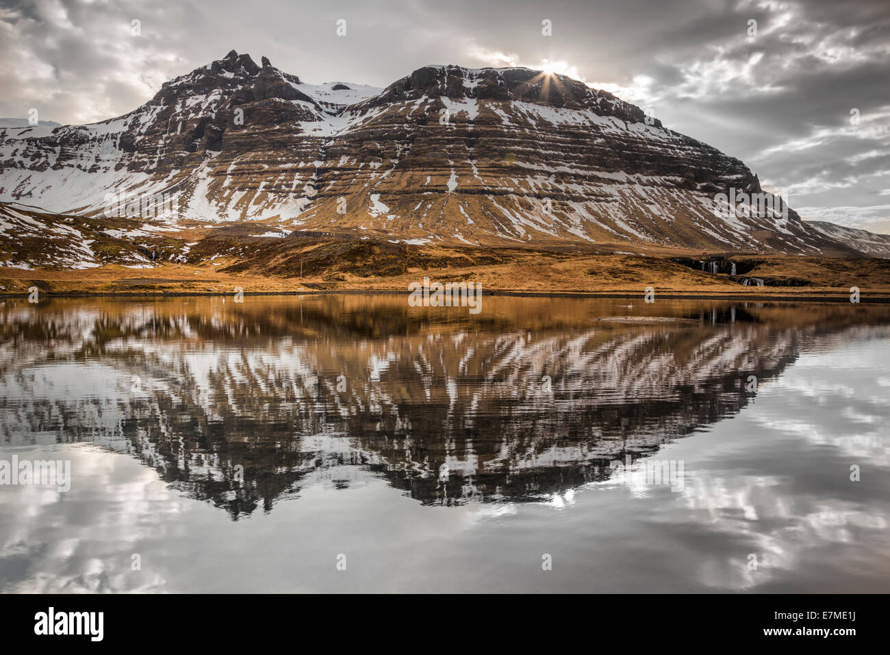 Las montañas de la costa Grundarfjordur reflejado en la bahía en un día nublado, la península de Snaefellsnes, en el oeste de Islandia. Foto de stock