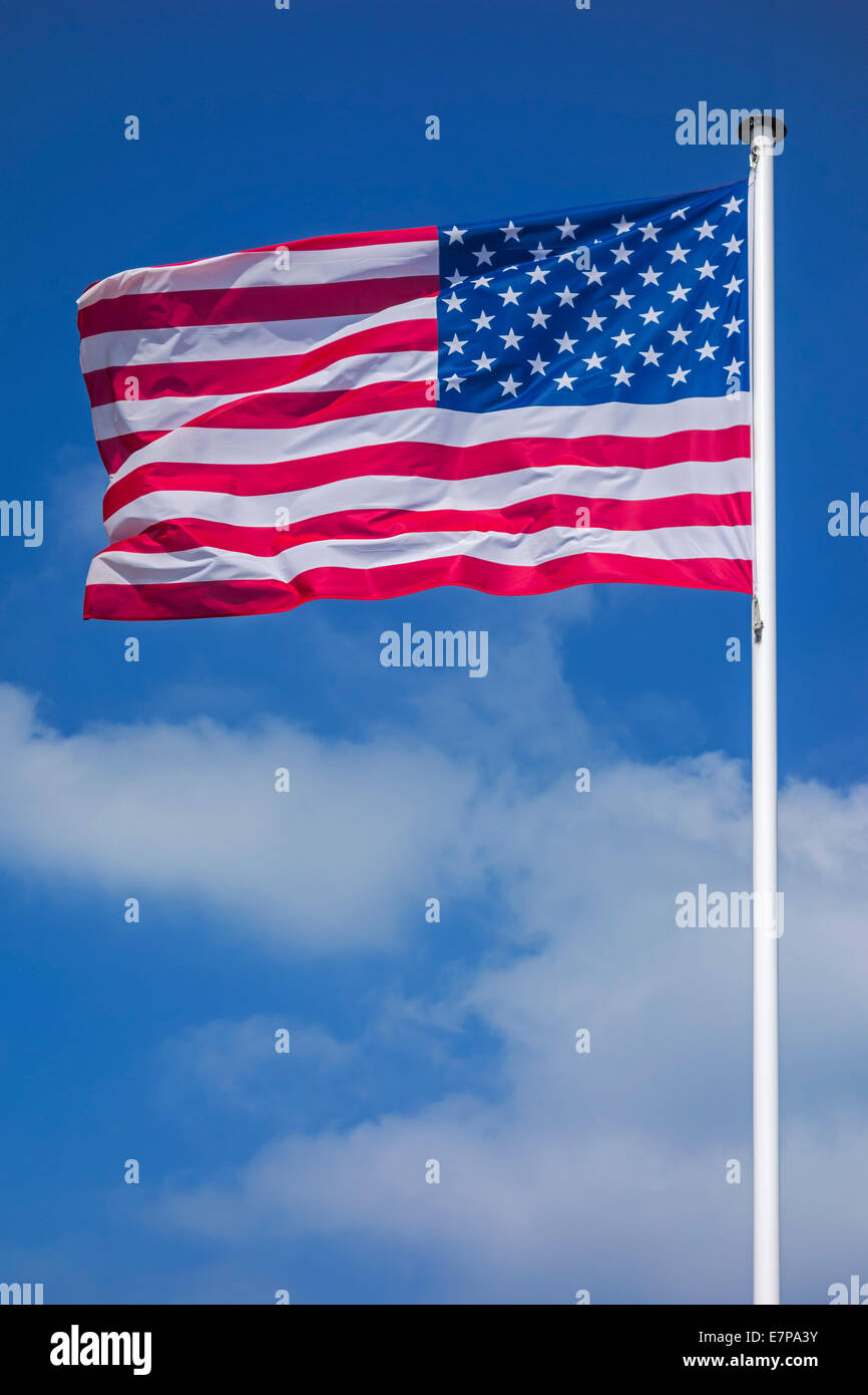 Estrellas y rayas / North American bandera nacional de los Estados Unidos sobre un mástil volando en el viento contra el cielo nublado Foto de stock