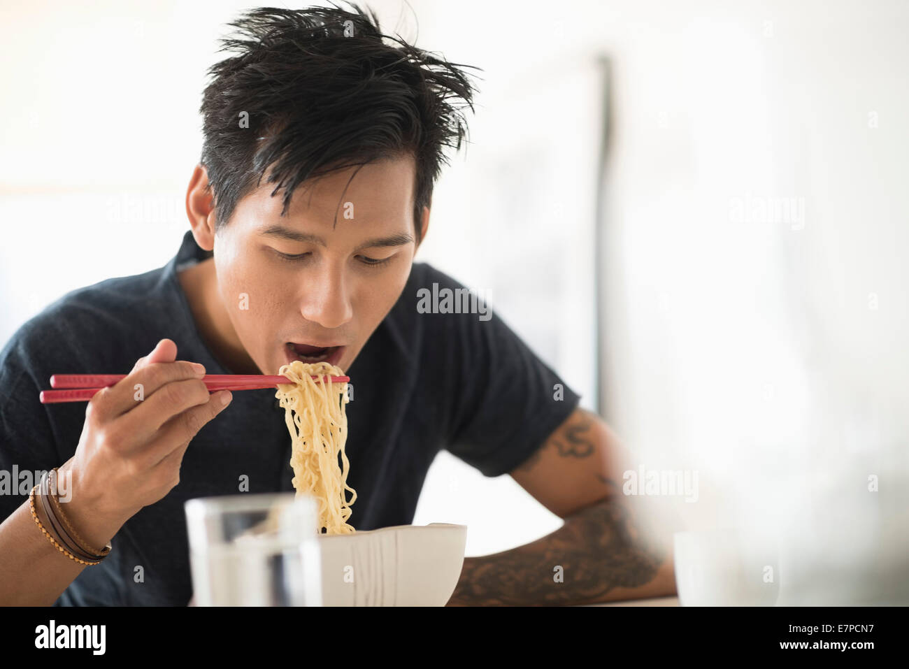 Hombre comiendo fideos con palillos chinos Fotografía de stock - Alamy