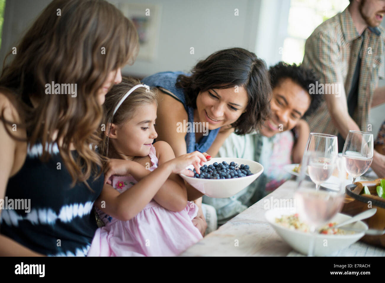 Una reunión familiar para una comida. Adultos y niños alrededor de una mesa. Foto de stock